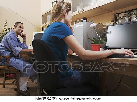 Stock Photo - Multi-ethnic couple working at home. Fotosearch
