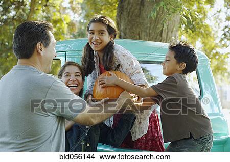 Multi-ethnic family holding pumpkin View Large Photo Image Picture - Multi-ethnic family holding pumpkin. Fotosearch