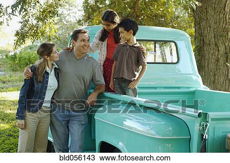 Stock Image - Multi-ethnic family in back of truck. Fotosearch