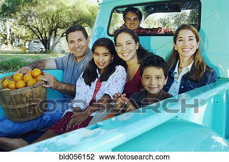 Stock Image - Multi-ethnic family in back of truck. Fotosearch