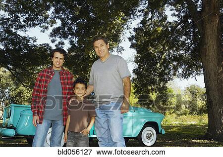 Stock Photo - Multi-ethnic family in front of truck. Fotosearch