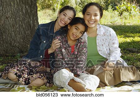 Multi-ethnic family sitting under tree View Large Photo Image Stock Image - Multi-ethnic family sitting under tree. Fotosearch