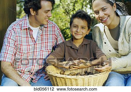 Stock Image - Multi-ethnic family with basket of organic produce. Fotosearch