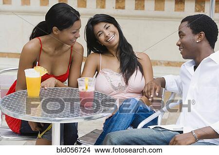 Picture - Multi-ethnic friends at outdoor cafe. Fotosearch