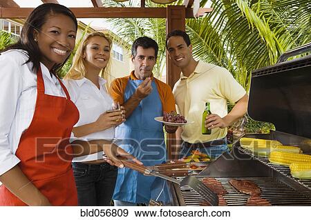Stock Photo - Multi-ethnic friends barbecuing. Fotosearch