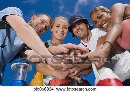 Picture - Multi-ethnic friends in huddle. Fotosearch