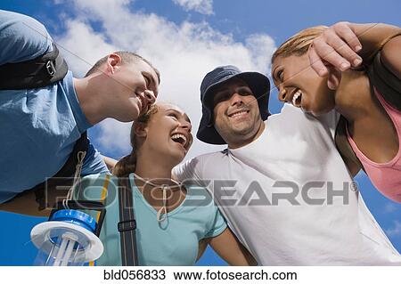 Stock Image - Multi-ethnic friends in huddle. Fotosearch