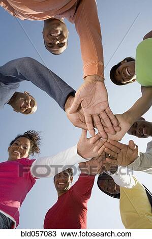 Stock Image - Multi-ethnic friends in huddle. Fotosearch