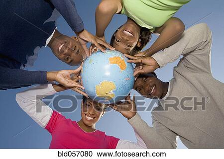 Stock Image - Multi-ethnic hands holding globe. Fotosearch