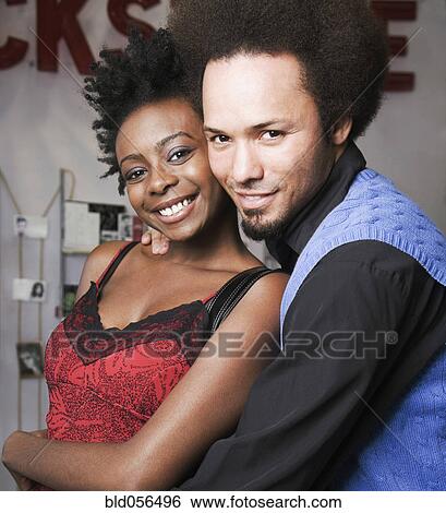 Stock Photograph - Multi-ethnic man and woman hugging. Fotosearch