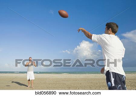 Stock Image - Multi-ethnic men playing catch. Fotosearch