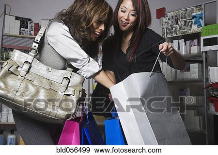 Multi-ethnic women looking in shopping bag View Large Photo Image Stock Photo - Multi-ethnic women looking in shopping bag. Fotosearch