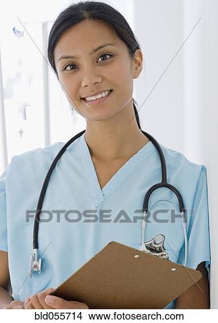 Picture - Pacific Islander female doctor holding chart . Fotosearch