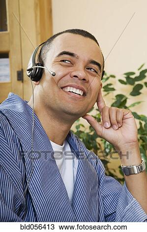 Stock Image - Pacific Islander man wearing headset. Fotosearch