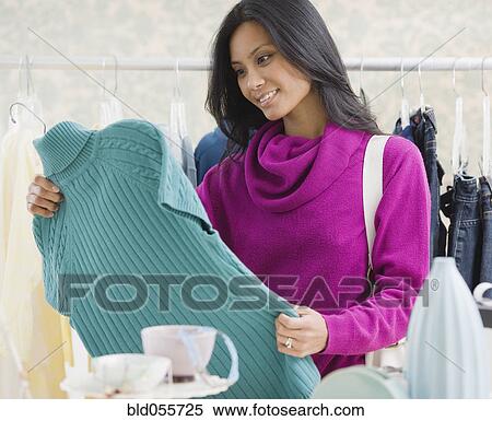 Stock Photography - Pacific Islander woman clothing shopping. Fotosearch