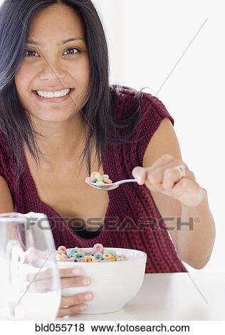 Stock Photo - Pacific Islander woman eating cereal. Fotosearch