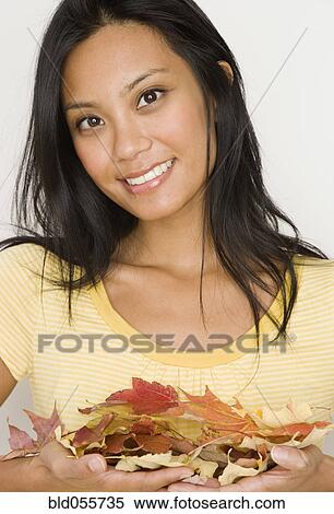 Pacific Islander woman holding autumn leaves View Large Photo Image Stock Photography - Pacific Islander woman holding autumn leaves. Fotosearch