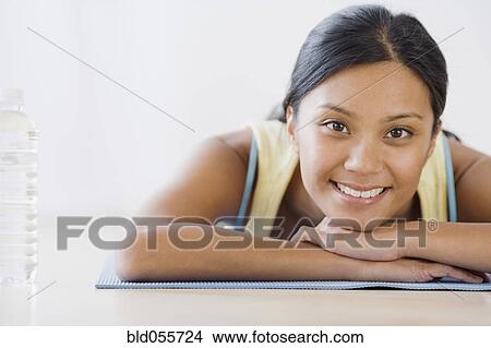 Pacific Islander woman laying on yoga mat View Large Photo Image Picture - Pacific Islander woman laying on yoga mat. Fotosearch
