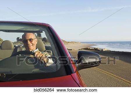 Picture - Senior German man driving convertible car. Fotosearch