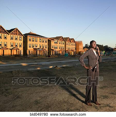 Stock Image - African American businesswoman at residential construction site. Fotosearch