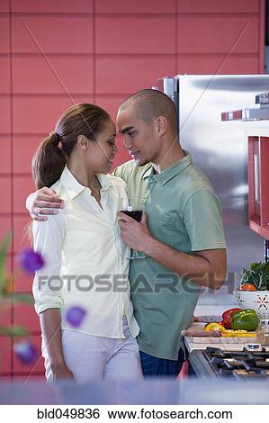Stock Photograph - African American couple hugging in kitchen. Fotosearch