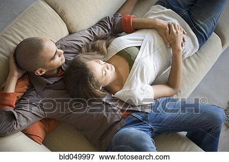 Stock Photo - African American couple laying on sofa. Fotosearch