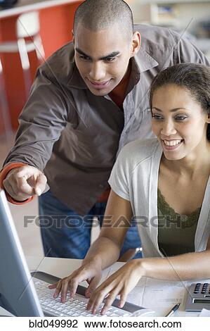 Stock Image - African American couple looking at computer. Fotosearch