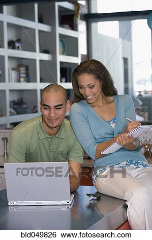 Stock Photograph - African American couple looking at laptop. Fotosearch
