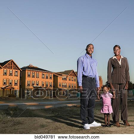 Stock Image - African American family at residential construction site. Fotosearch