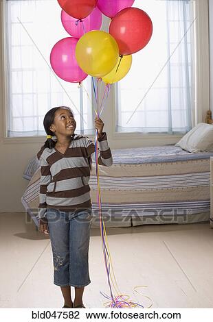 African American girl holding bunch of balloons View Large Photo Image Stock Image - African American girl holding bunch of balloons. Fotosearch