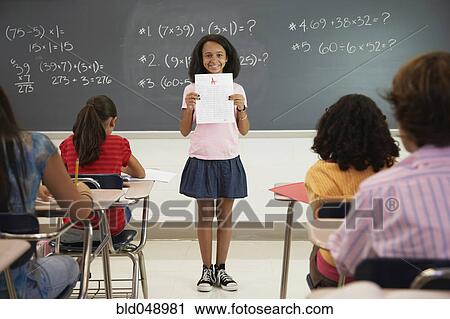 African American girl holding paper in front of class View Large Photo Image Stock Image - African American girl holding paper in front of class. Fotosearch