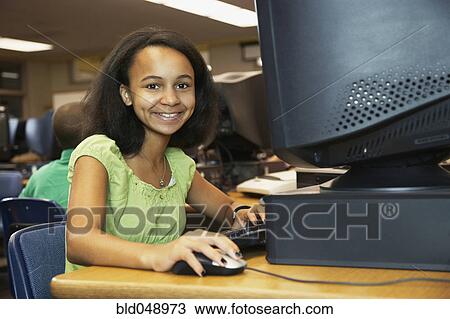 Stock Image - African American girl using school computer. Fotosearch