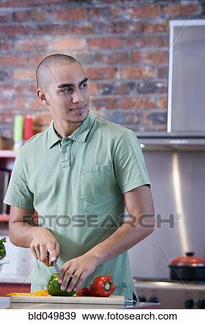 Stock Photo - African American man chopping vegetables. Fotosearch