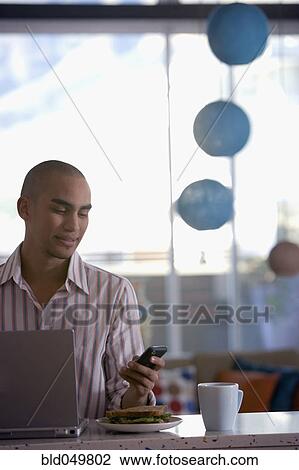 Stock Image - African American man dialing cell phone. Fotosearch