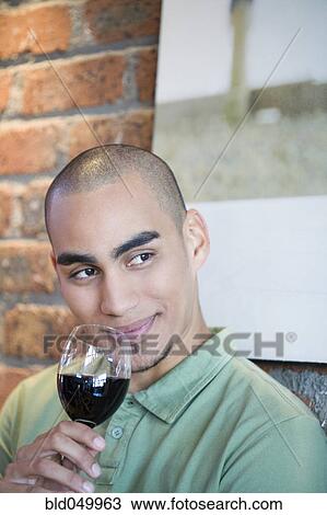Stock Image - African American man drinking wine. Fotosearch