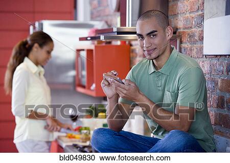 Stock Image - African American man holding electronic organizer. Fotosearch