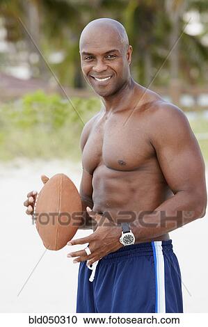 African American man holding football View Large Photo Image Stock Image - African American man holding football. Fotosearch