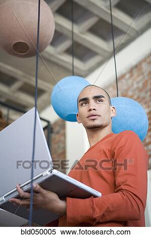 African American man holding laptop View Large Photo Image Stock Photography - African American man holding laptop. Fotosearch