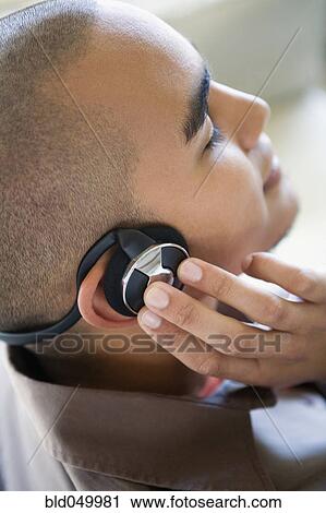 Stock Image - African American man listening to headphones. Fotosearch