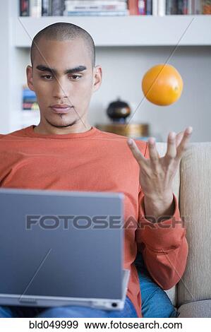 Stock Photo - African American man looking at laptop. Fotosearch
