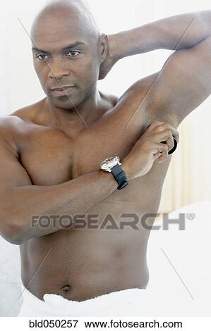 African American man putting on deodorant View Large Photo Image Stock Photo - African American man putting on deodorant. Fotosearch