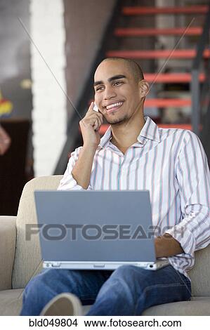 Picture - African American man talking on cell phone. Fotosearch