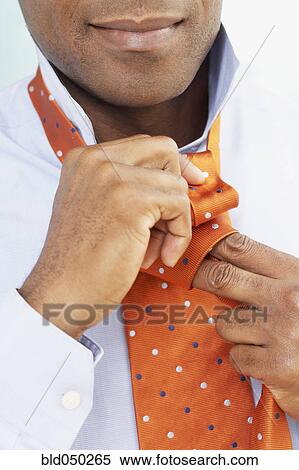 African American man tying necktie View Large Photo Image Stock Photography - African American man tying necktie. Fotosearch