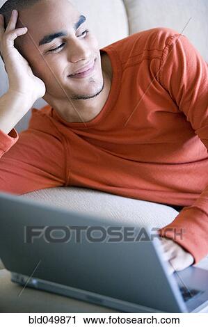 Stock Image - African American man typing on laptop. Fotosearch