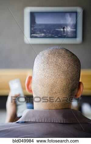Picture - African American man watching television. Fotosearch