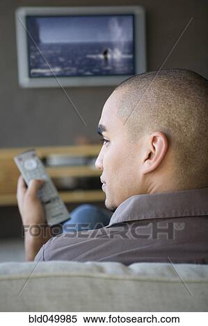 Stock Photography - African American man watching television. Fotosearch