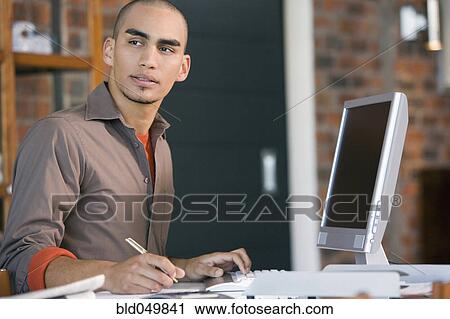 Stock Image - African American man working at home. Fotosearch