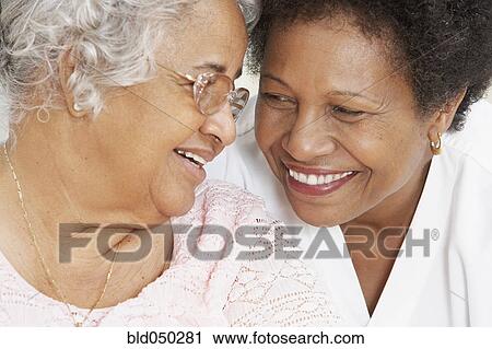 African American mother and adult daughter smiling at each other View Large Photo Image Stock Image - African American mother and adult daughter smiling at each other. Fotosearch