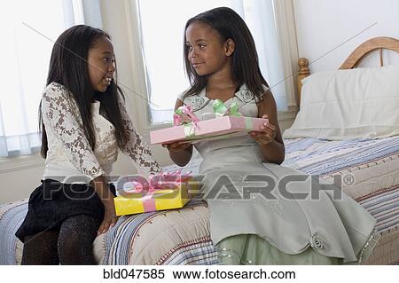 African American sisters exchanging gifts View Large Photo Image Stock Photography - African American sisters exchanging gifts. Fotosearch