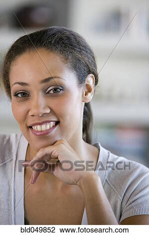 Stock Image - African American woman leaning chin on hand. Fotosearch